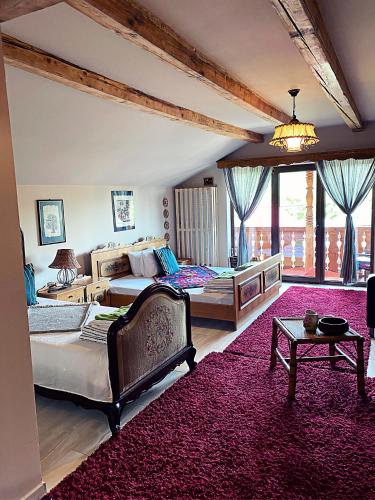 a large bedroom with two beds and a red rug at La Curtea Veche in Lăpuş