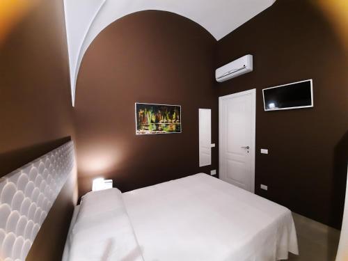 a bedroom with a white bed and a black wall at Zia Nennè Holiday Rooms in Monopoli