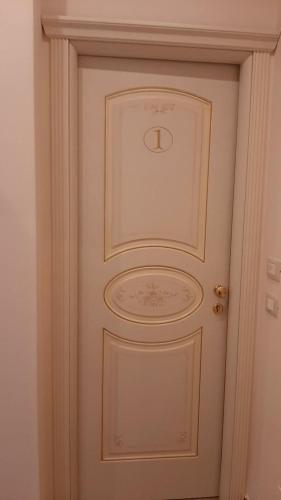 a white door with a gold knocker on it at B&B Orchidea in Gioia Tauro