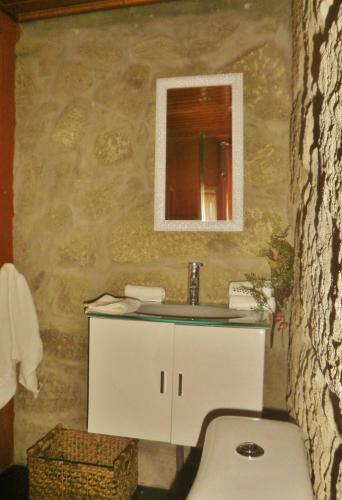 a bathroom with a sink and a mirror at Village Minhoure in Felgueiras