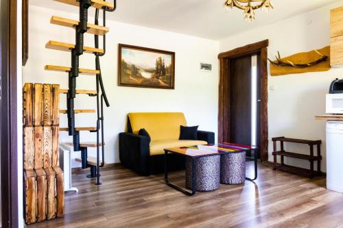 a living room with a ladder and a chair and a table at Chata Umilajka in Czarna