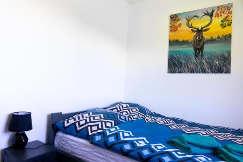 a bedroom with a bed with a picture of a deer on the wall at Chata Umilajka in Czarna