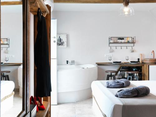 a bathroom with a tub and a bed and a sink at Secret Gem Suites in Oia