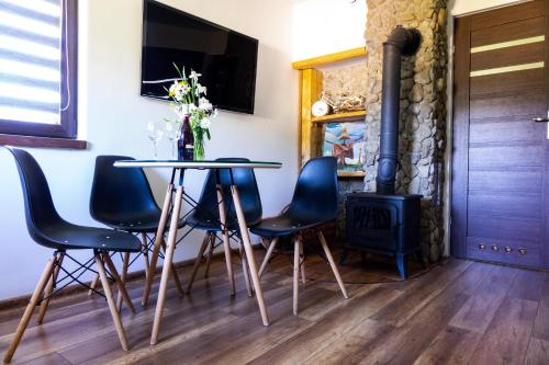 a dining room with a table and chairs and a fireplace at Chata Umilajka in Czarna