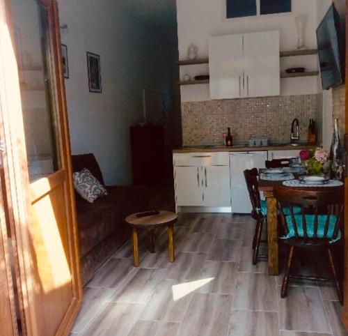 een keuken en een woonkamer met een tafel en een bank bij Apartmani Ninić in Trebinje