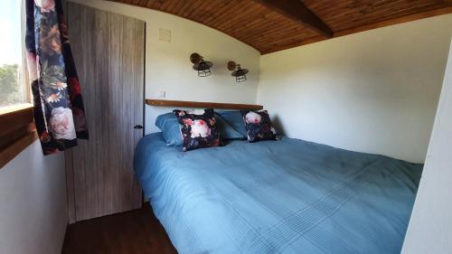 a bedroom with a bed with blue sheets and pillows at Tisza White House in Tiszaszőlős