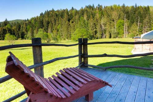 a wooden bench sitting on top of a wooden deck at Chata Umilajka in Czarna