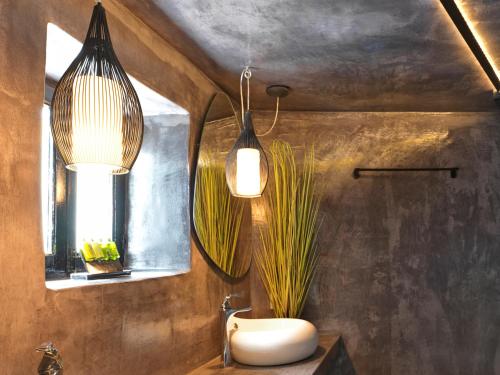 a bathroom with two pendant lights and a sink at Secret Gem Suites in Oia