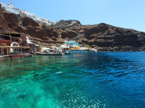 a large body of water with a group of boats at Secret Gem Suites in Oia