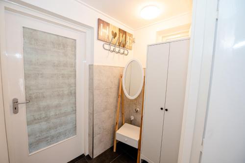 baño con espejo y puerta blanca en B&B Het Station bij Snowworld GaiaZoo en Mondo Verde en Landgraaf