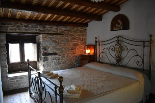 a bedroom with a bed in a stone building at Helikon -la dimora del viandante- in Montalbano Elicona