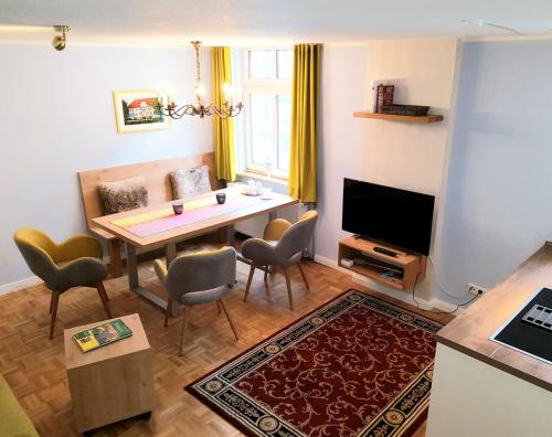 a living room with a table and chairs and a television at Das Nachtwächterhäuschen in Tecklenburg
