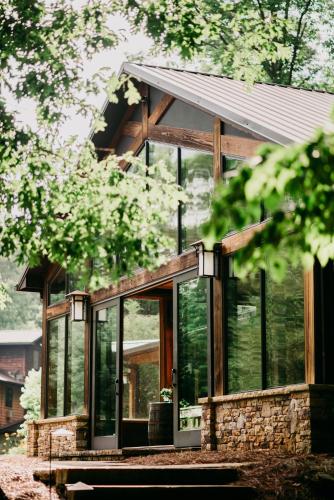 a glass house with a metal roof at Sylvan Valley Lodge and Cellars in Sautee Nacoochee