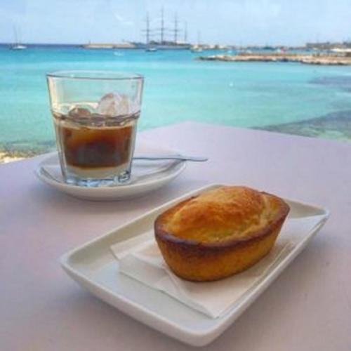 un prodotto da forno su un piatto accanto a un bicchiere d'acqua di Villa Raffaela a Sanarica