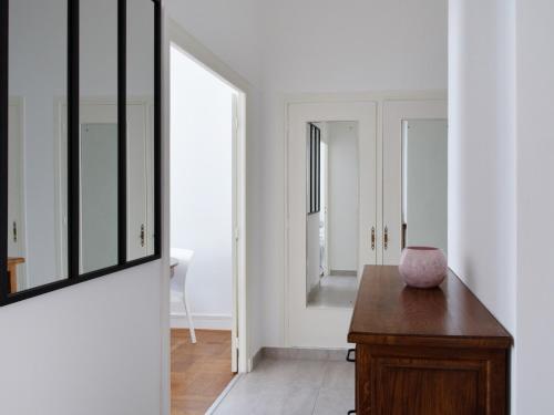 Habitación con espejo y mesa de madera. en Nice, 58 M2 ! superbe appartement climatisé, 3 couchages, proche de la promenade des Anglais et de la Gare ! en Niza