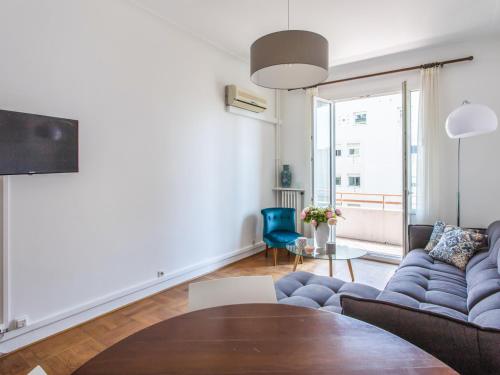 sala de estar con sofá azul y mesa en Nice, 58 M2 ! superbe appartement climatisé, 3 couchages, proche de la promenade des Anglais et de la Gare ! en Niza