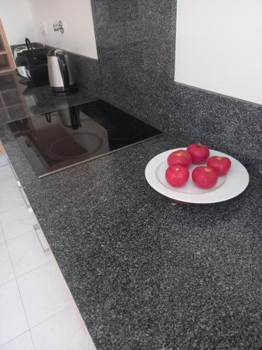 a plate of tomatoes on a counter in a kitchen at La Suite Calypso in Luz