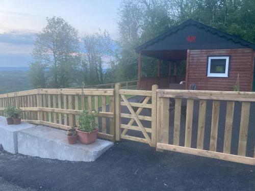 a wooden fence in front of a cabin at Kabin in the woods with Hot Tub in Llandybie