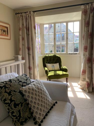 a bedroom with a bed and a chair and windows at Wee Grange in Bath