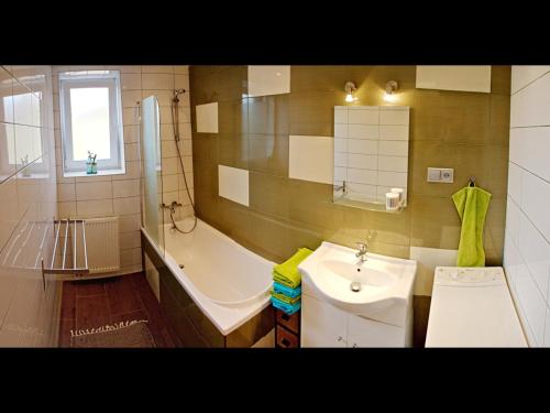 a bathroom with a tub and a sink and a bath tub at Apartment Pod Sychrovem in Prague