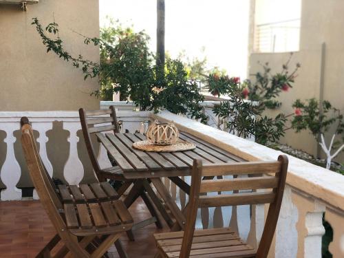 drewniany stół i 2 krzesła na balkonie w obiekcie Ayerina Ground floor Apartment w mieście Arillas