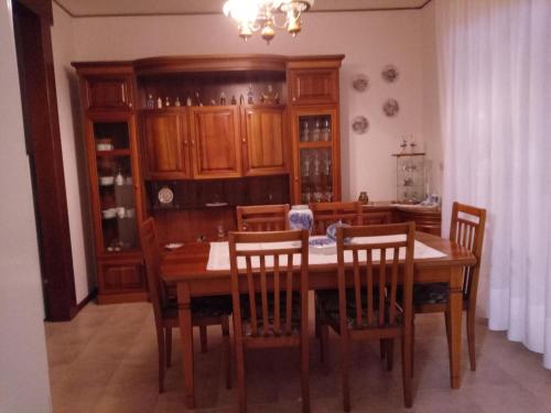 a dining room with a wooden table and chairs at La Cjase di Pieri e Vilme in Udine