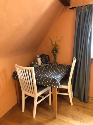 a table with two chairs and a black and white polka dot seat at Gästezimmer Adenau in Adenau
