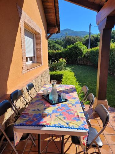 a table with a colorful table cloth on a patio at Casa de campo Aires de Gredos in Candeleda