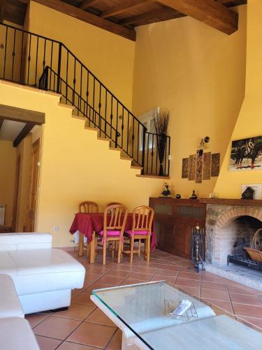a living room with a table and a fireplace at Casa de campo Aires de Gredos in Candeleda