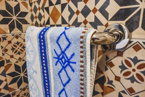 - une serviette suspendue à un porte-serviettes dans la salle de bains dans l'établissement Sobe - rooms R&K, à Bohinj