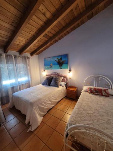 a bedroom with a white bed and a window at Casa de campo Aires de Gredos in Candeleda