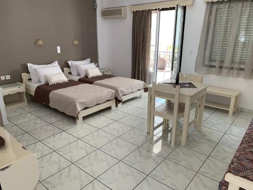 a bedroom with two beds and a table and a desk at Argo in Skala