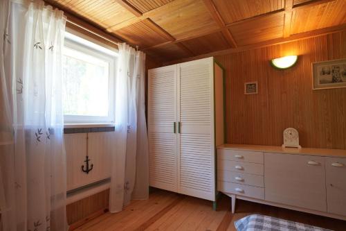 Garden apartment في بريلا: غرفة نوم مع خزانة ملابس ونافذة وخزانة