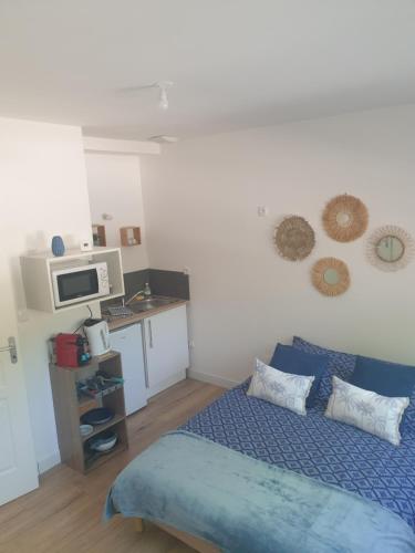 une chambre avec un lit bleu et une cuisine dans l'établissement Henriville Studio n °1, à Amiens