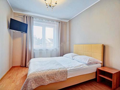 a bedroom with a large bed and a window at Pokoje Arka in Międzywodzie