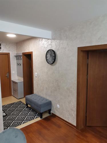 a room with a clock on the wall and a stool at NOVAK apartman in Vrnjačka Banja