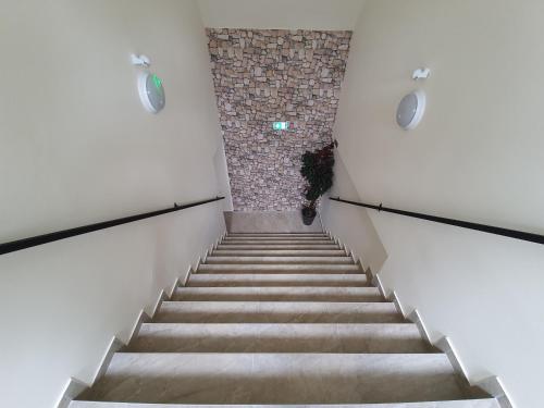 a staircase in a building with a stone wall at Harmónia Panzió in Bogács