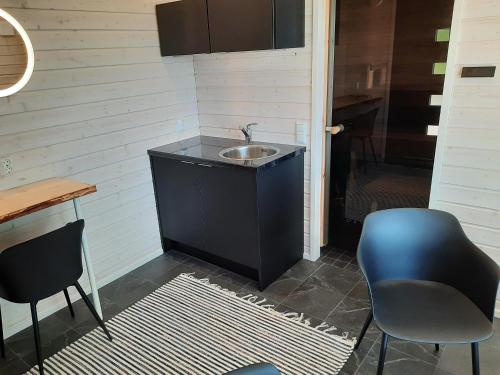 baño con lavabo y 2 sillas en Villa Hiili, en Ähtäri