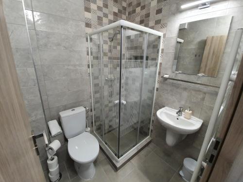 a bathroom with a shower and a toilet and a sink at Harmónia Panzió in Bogács