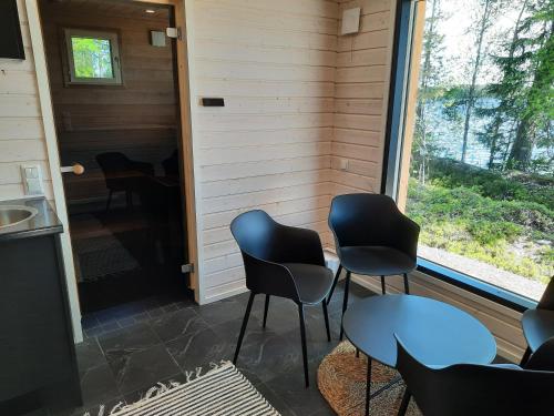 Habitación con 4 sillas, mesa y ventana en Villa Hiili, en Ähtäri