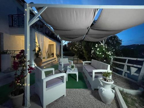 a patio area with chairs, tables and umbrellas at Villa Rosa in Agropoli