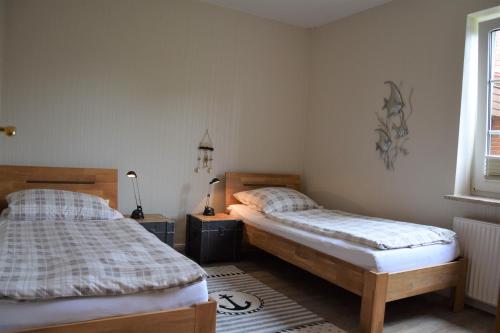 比蘇姆的住宿－Haus Amrum 21****，一间卧室设有两张床和窗户。