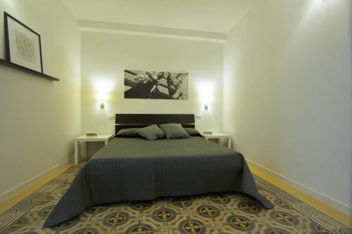 a bedroom with a large bed with two tables at Via Roma 10 in Trapani