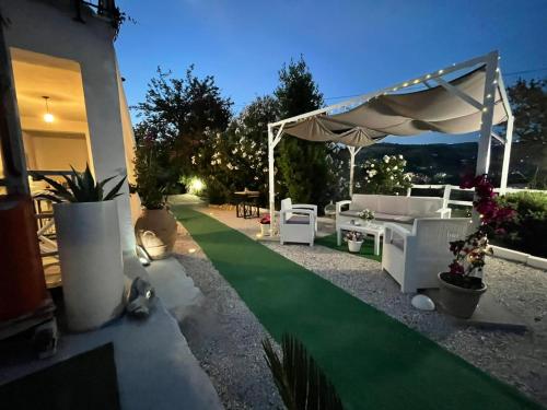 a patio area with tables, chairs and umbrellas at Villa Rosa in Agropoli