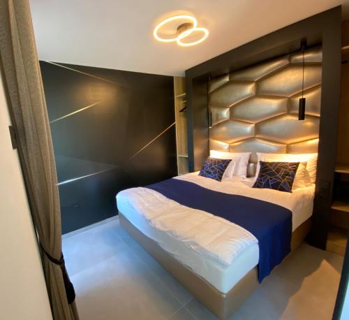 a bedroom with a large bed with a large headboard at Relax Sauna Apartman privát finn szaunával in Keszthely