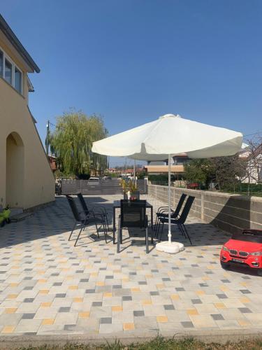 a table and chairs under an umbrella on a patio at Apartment CReO Loborika in Marčana