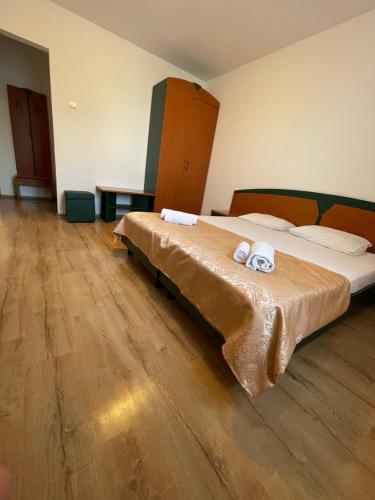 a bedroom with two beds and a wooden floor at Hotel Oltenia in Eforie Sud