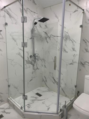 W łazience wyłożonej białym marmurem znajduje się kabina prysznicowa. w obiekcie Eurolux Boutique-Hotel w Taszkiencie