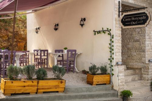 um restaurante com uma mesa e cadeiras num pátio em Mare Casia Bozcaada Otel em Bozcaada