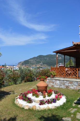 a flower bed with a vase in the grass at Remvi Apartments in Skopelos Town